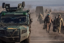 Soldiers and an armored car on a dirt road
