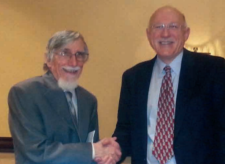 Robert Jervis shaking hands with Barry Posen