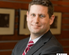 headshot of Russell Rumbaugh in a suit and tie